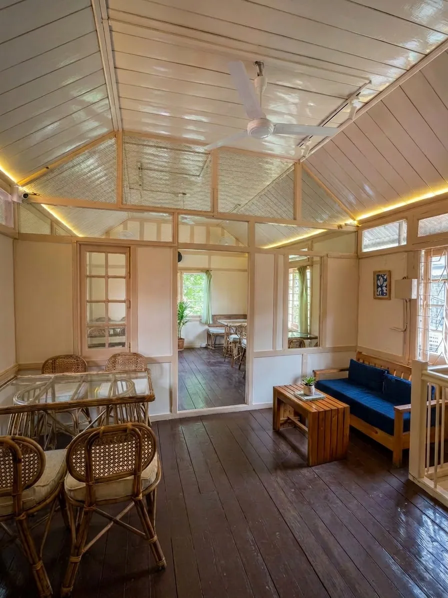 Upstairs dining room with a dark wood floor, cane dining sets and a blue banquette sofa